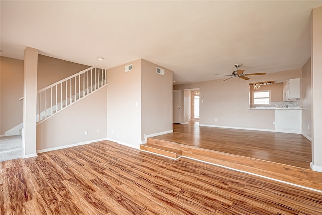 unfurnished living room featuring ceiling fan and light hardwood / wood-style floors