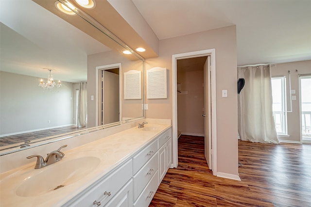 bathroom with wood-type flooring, vanity, and an inviting chandelier