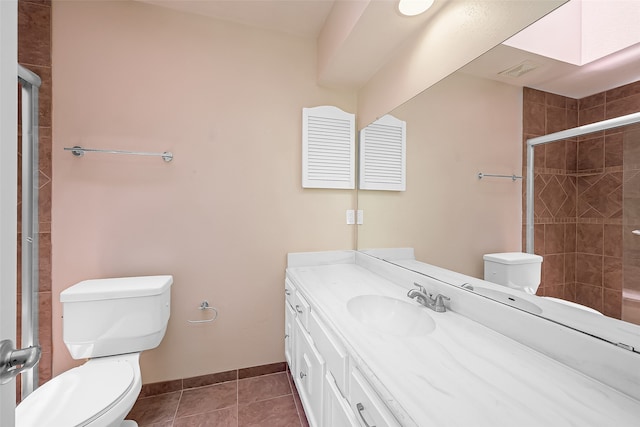 bathroom featuring walk in shower, vanity, toilet, and tile patterned floors