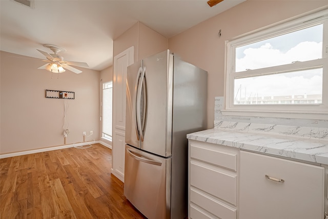 kitchen featuring stainless steel refrigerator, light hardwood / wood-style floors, ceiling fan, and white cabinets