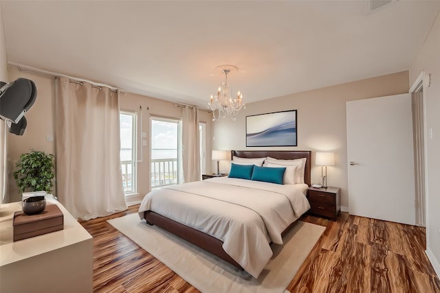 bedroom with a notable chandelier and wood-type flooring