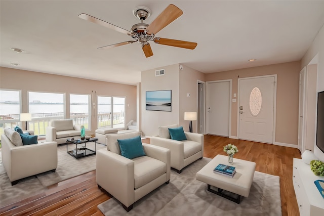 living room featuring light hardwood / wood-style floors and ceiling fan