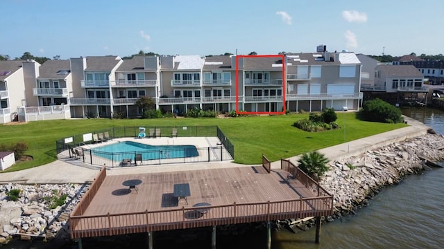 exterior space with a water view, a yard, a balcony, and a community pool