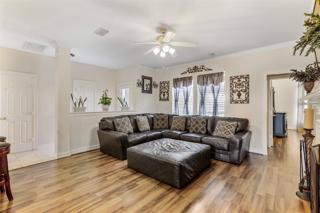 living room with light wood-type flooring, ornate columns, ceiling fan, and ornamental molding