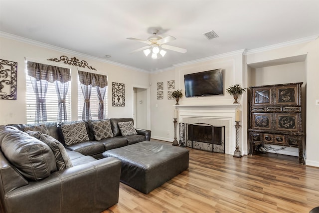 living room featuring ceiling fan, wood-type flooring, and crown molding