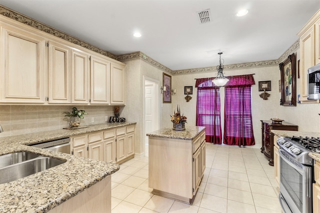 kitchen with sink, light tile patterned floors, pendant lighting, a kitchen island, and appliances with stainless steel finishes