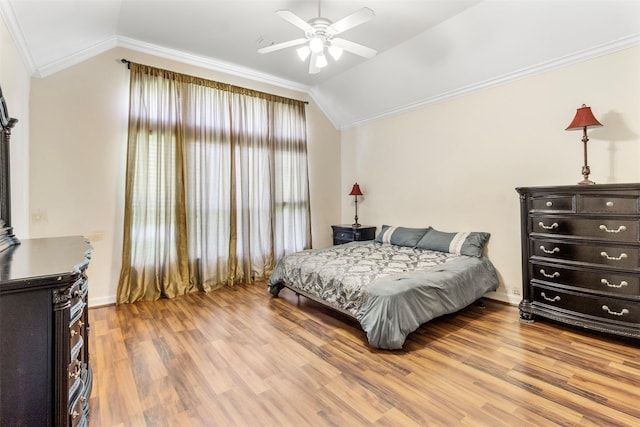 bedroom featuring light wood-type flooring, vaulted ceiling, ceiling fan, and crown molding