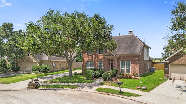 view of front facade featuring a front yard, a garage, and central air condition unit