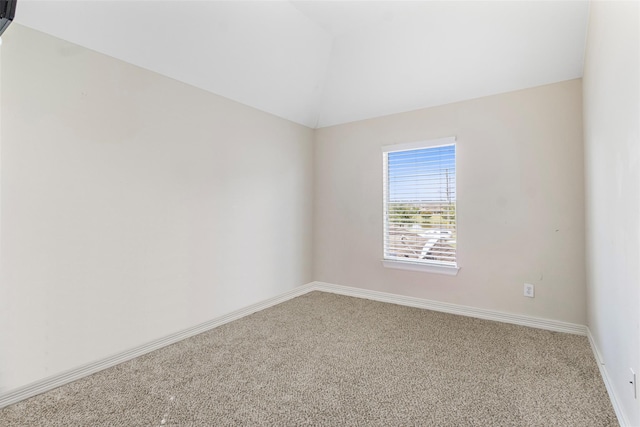 spare room featuring carpet flooring and lofted ceiling