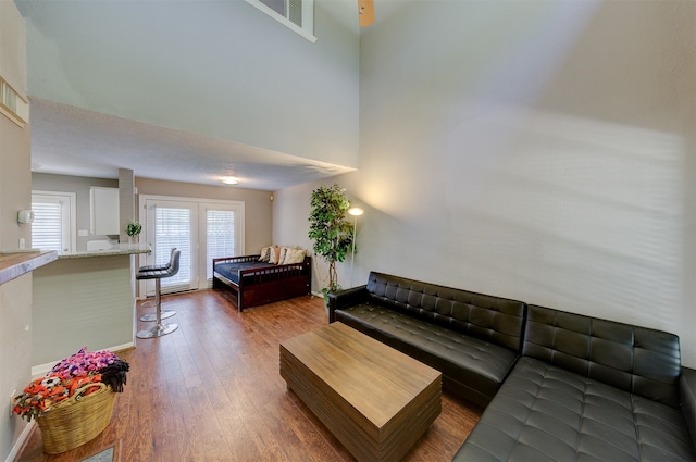 living room with a towering ceiling and hardwood / wood-style flooring