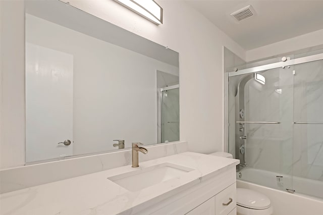 full bathroom with shower / bath combination with glass door, vanity, and toilet