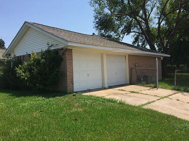 garage with a lawn and central air condition unit