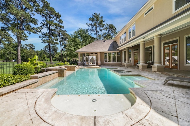 view of swimming pool with french doors, an in ground hot tub, and a patio area