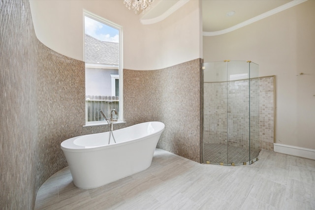 bathroom featuring ornamental molding, shower with separate bathtub, and tile walls