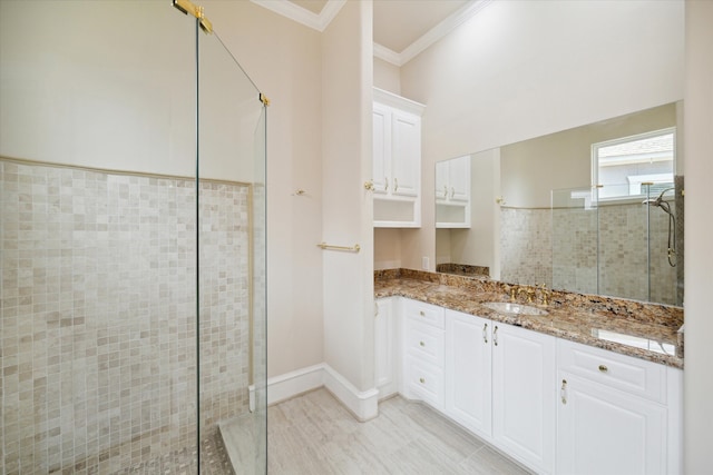 bathroom with vanity, ornamental molding, and a shower with door