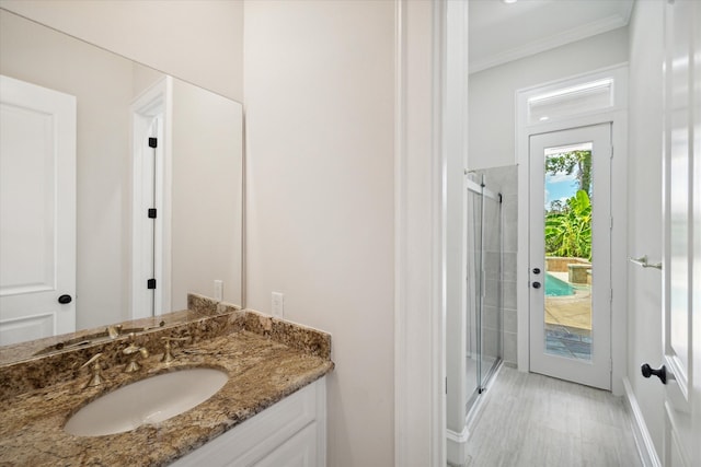 bathroom featuring walk in shower, vanity, crown molding, and hardwood / wood-style floors