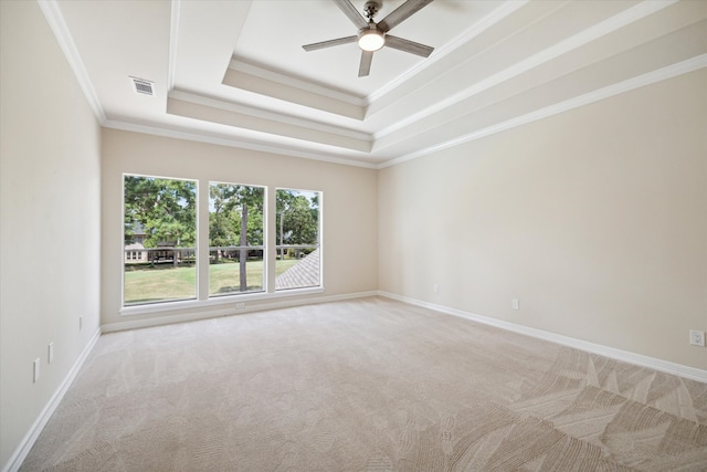 carpeted spare room with ceiling fan, a raised ceiling, and crown molding