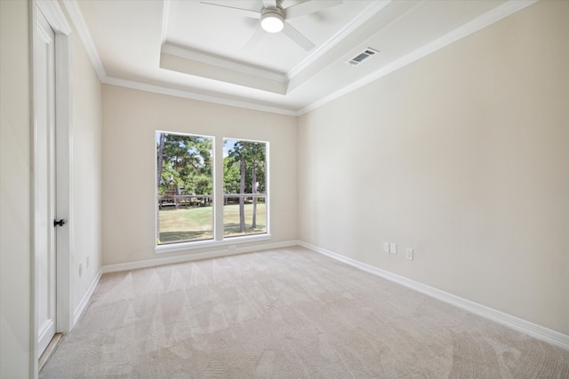 carpeted empty room with a tray ceiling, ceiling fan, and crown molding