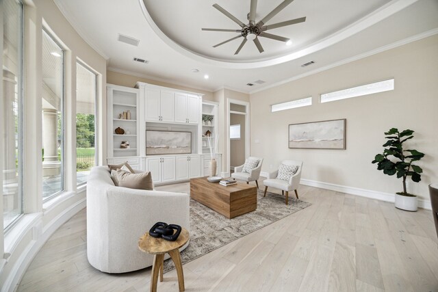 living room featuring a tray ceiling, ceiling fan, and light hardwood / wood-style flooring