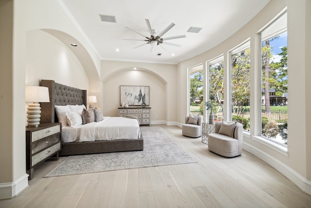 bedroom with ornamental molding, light wood-type flooring, and ceiling fan