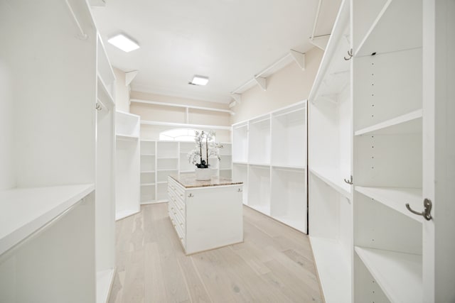 walk in closet with light hardwood / wood-style floors