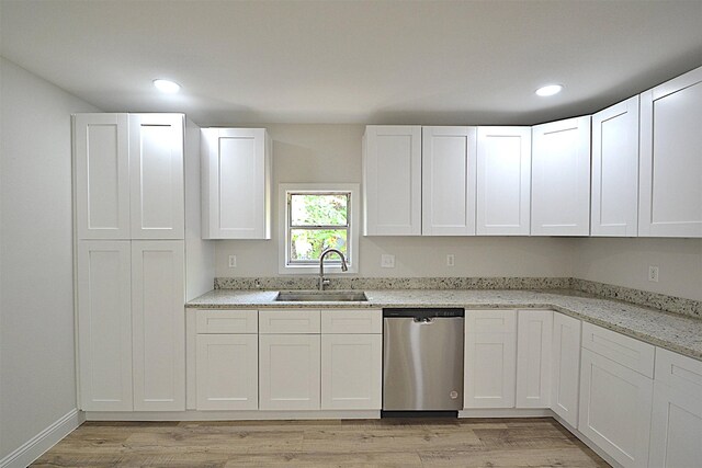 kitchen with light stone countertops, dishwasher, sink, and light hardwood / wood-style flooring