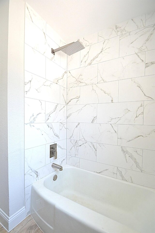 bathroom featuring tiled shower / bath combo and hardwood / wood-style floors