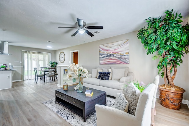 living room with ceiling fan and light hardwood / wood-style floors