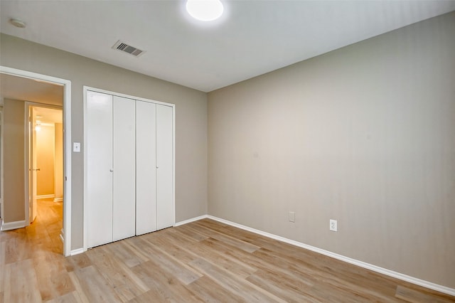 unfurnished bedroom with light hardwood / wood-style flooring and a closet