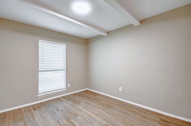 unfurnished room featuring hardwood / wood-style floors, plenty of natural light, and beam ceiling