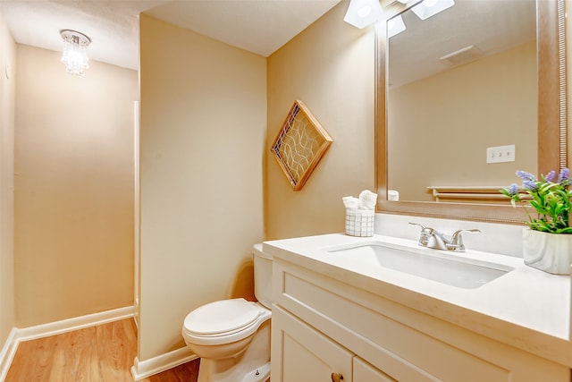 bathroom with hardwood / wood-style floors, vanity, and toilet