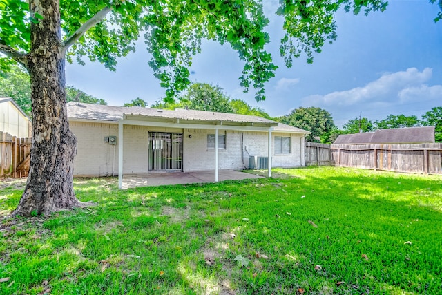 rear view of property featuring a patio area and a yard