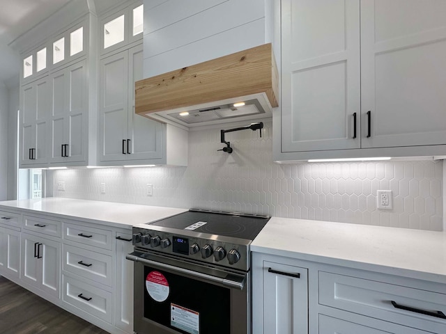 kitchen with dark hardwood / wood-style flooring, custom range hood, decorative backsplash, high end range, and white cabinetry