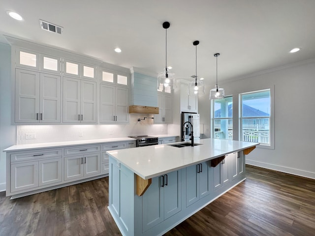 kitchen featuring electric range oven, sink, custom range hood, an island with sink, and dark hardwood / wood-style flooring