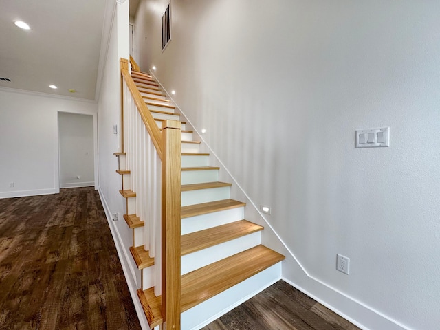 staircase featuring ornamental molding and hardwood / wood-style flooring