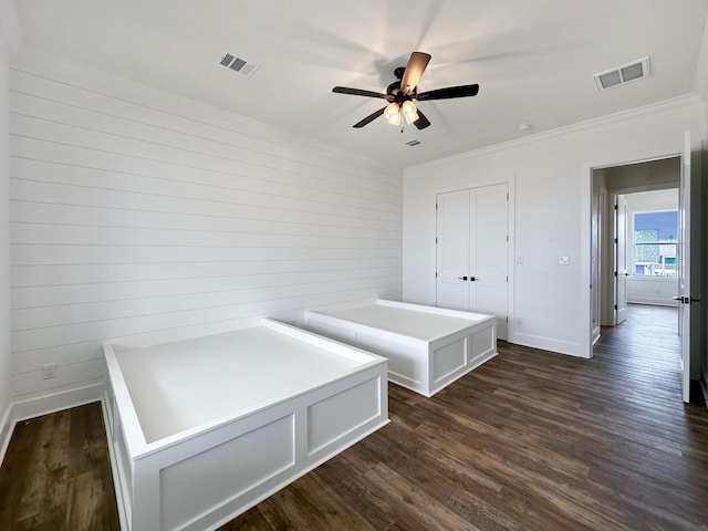 interior space featuring ceiling fan, crown molding, a closet, and dark hardwood / wood-style floors