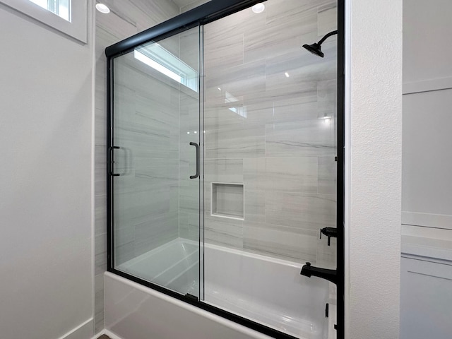 bathroom with shower / bath combination with glass door