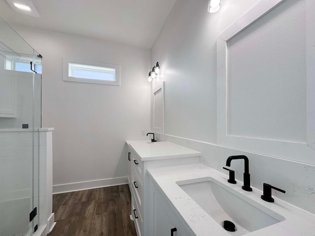 bathroom featuring a shower with shower door, hardwood / wood-style flooring, and vanity