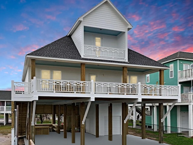 back house at dusk featuring a balcony