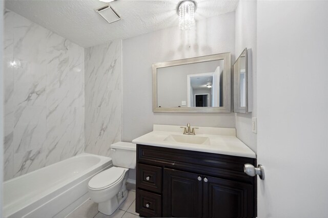 full bathroom featuring vanity, tile patterned floors, a textured ceiling, tiled shower / bath, and toilet