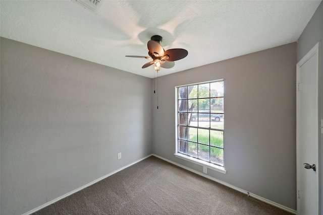 carpeted spare room featuring ceiling fan and a textured ceiling