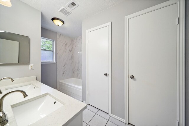 bathroom with a textured ceiling, tile patterned flooring, tub / shower combination, and double sink vanity