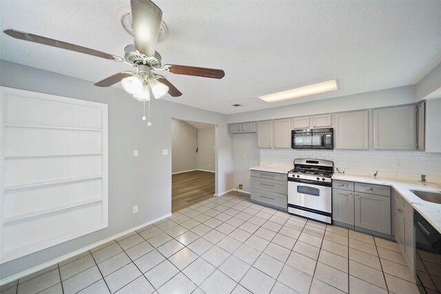 kitchen featuring backsplash, black appliances, ceiling fan, light tile patterned flooring, and gray cabinets