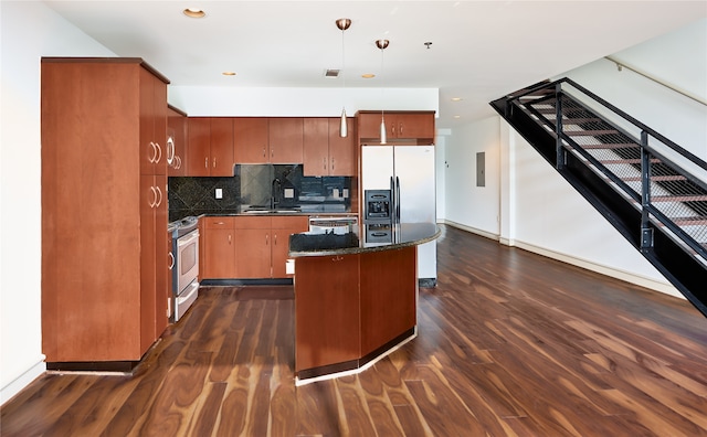 kitchen featuring hanging light fixtures, appliances with stainless steel finishes, a kitchen island, and dark hardwood / wood-style flooring