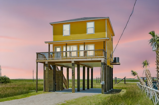 view of front of property with a porch, central AC, and a carport