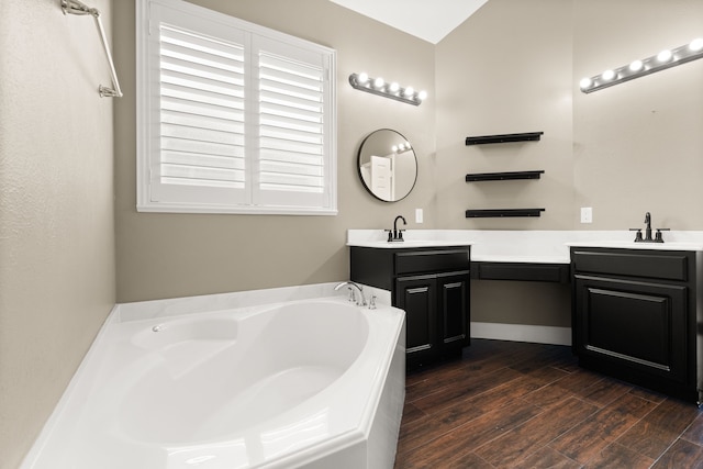 bathroom featuring double sink vanity, a tub to relax in, and hardwood / wood-style flooring