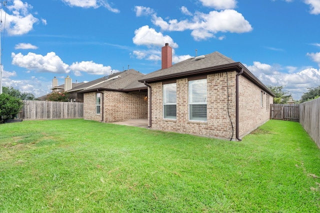 back of property featuring a patio area and a yard