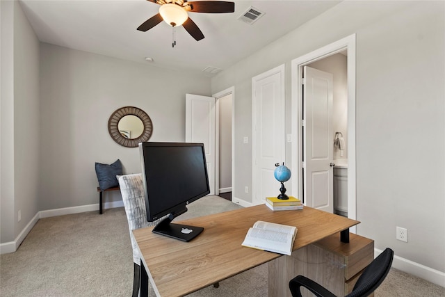 carpeted home office featuring ceiling fan