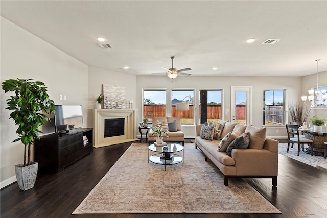 living room featuring dark hardwood / wood-style flooring and ceiling fan with notable chandelier