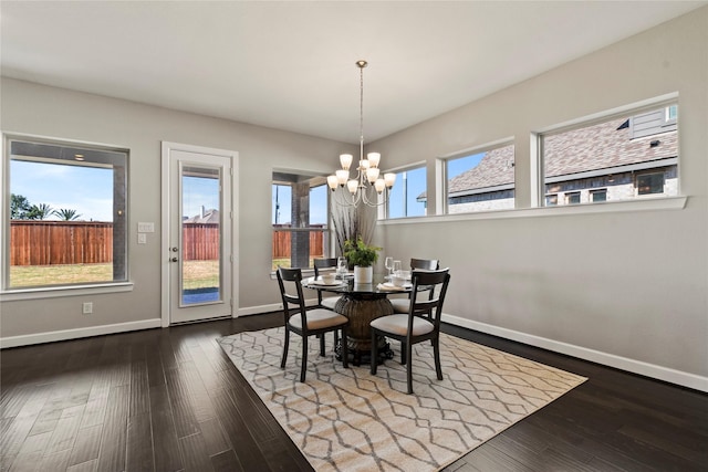 dining space with a healthy amount of sunlight, dark hardwood / wood-style floors, and an inviting chandelier